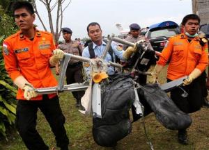 Search and rescue personnel carry the seats of AirAsia Flight 8501 after being airlifted by a US Navy helicopter at the airport in Pangkalan Bun, Indonesia today.