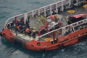 Part of AirAsia Flight 8501 is lifted to the Crest Onyx ship in the Java Sea.