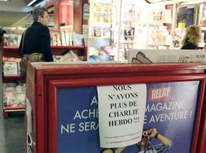People browse a newsstand advertising We don't have any more Charlie Hebdo in Paris, France, today.